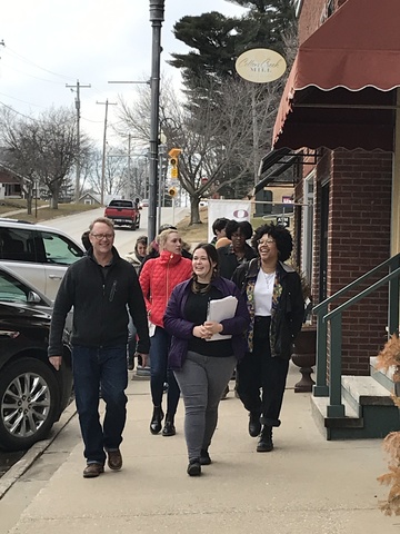 A group of students walk down the sidewalk together