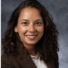 Brown-skinned woman in front of marbled grey background
