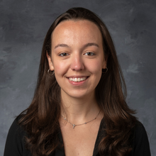 Woman in black shirt sits in front of black marbled background