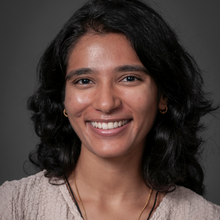 Brown woman in front of marbled grey background
