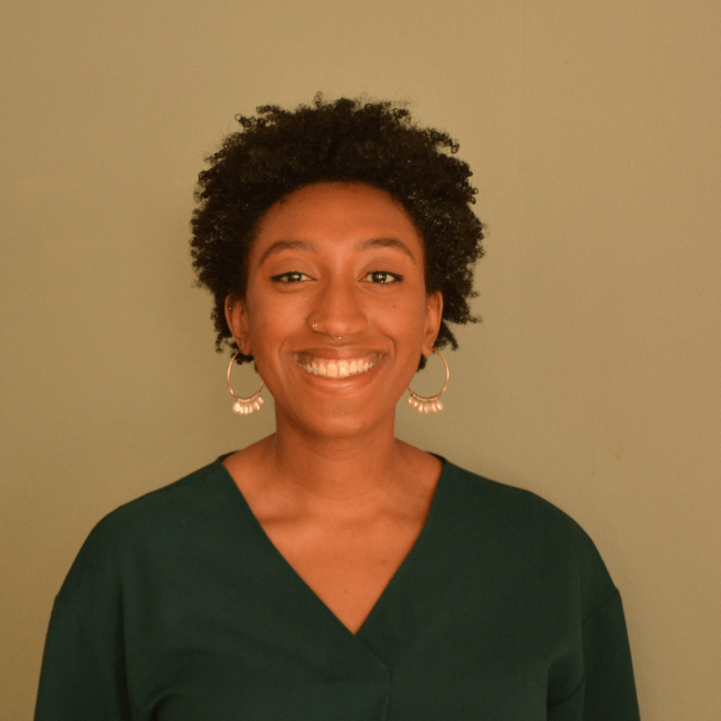 Woman smiling with brown background.