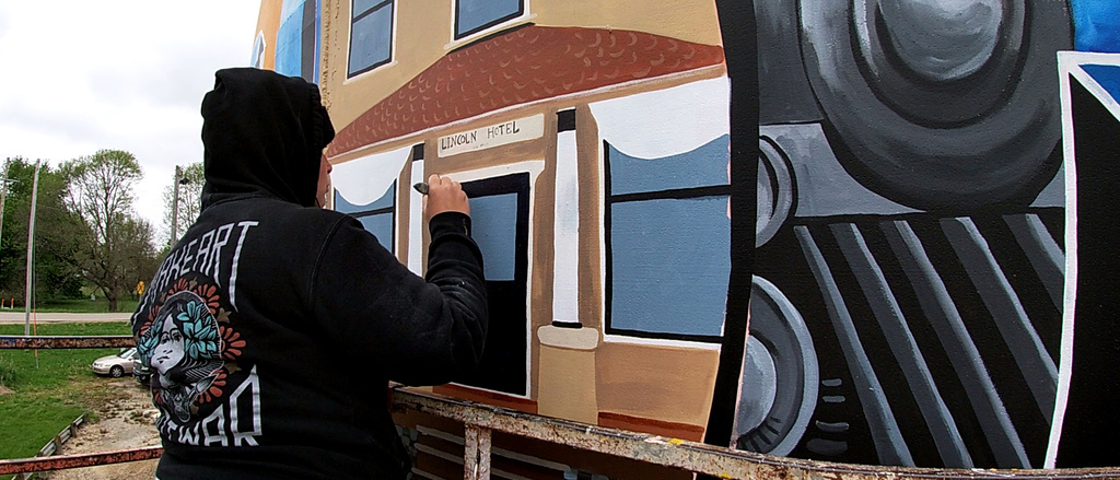 Student painting a train mural