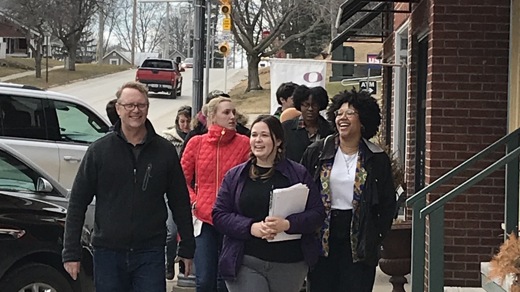 A group of students walk down the sidewalk together